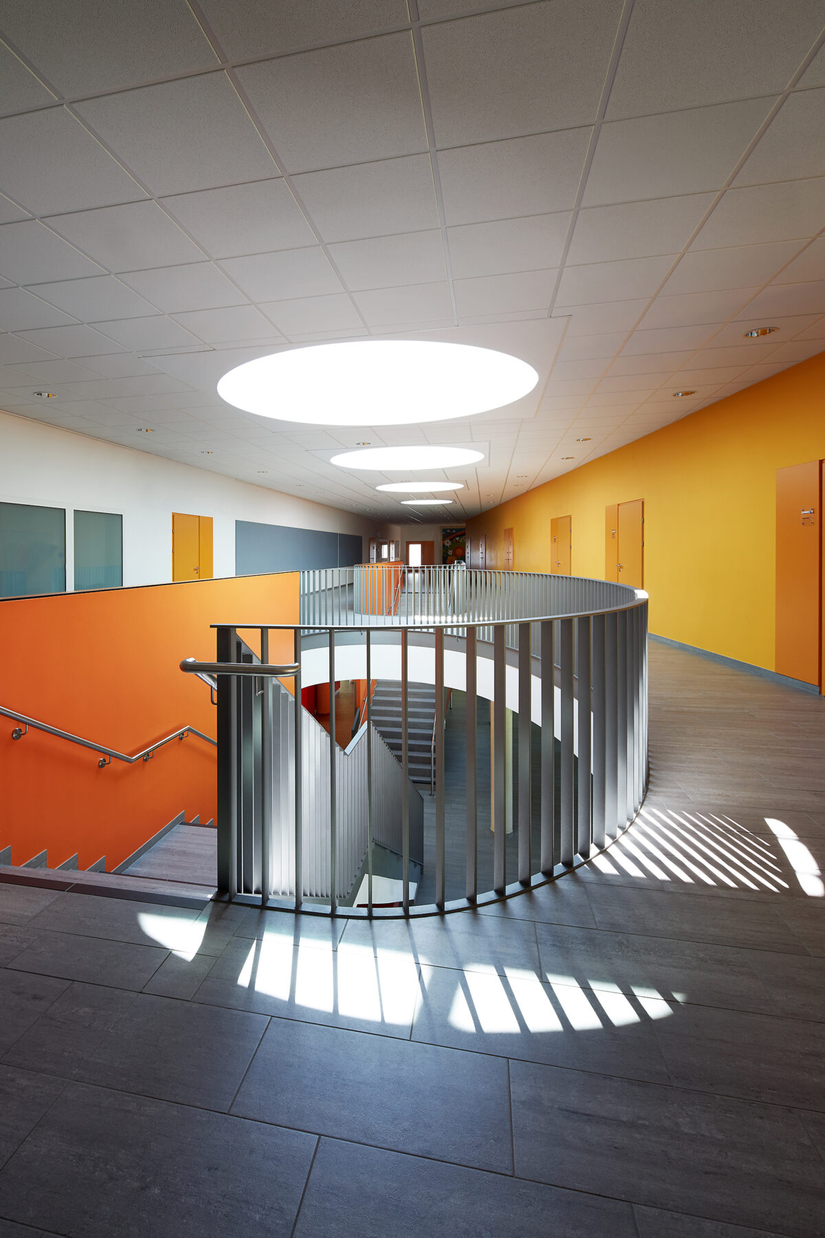 Architekturfotografie eines modernen Schul-Treppenhauses in Oberösterreich mit Licht- und Schattenspiel von Haderer Architektur.
