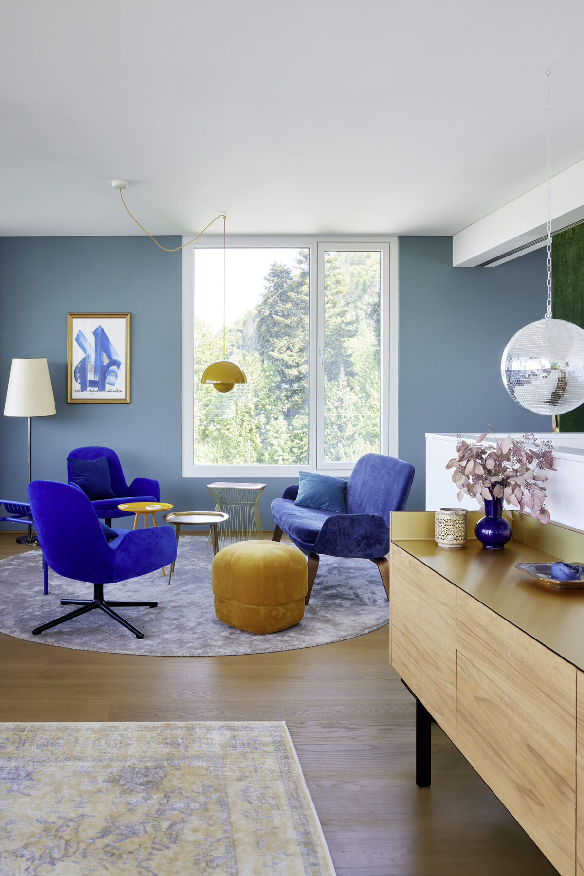 Stilvolles Wohnzimmer-Interieur mit einer blauen Akzentwand und modernen Designmöbeln, geplant von Gahleitner Architekten, professionelle Architekturfotografie von Roland Wimmer.