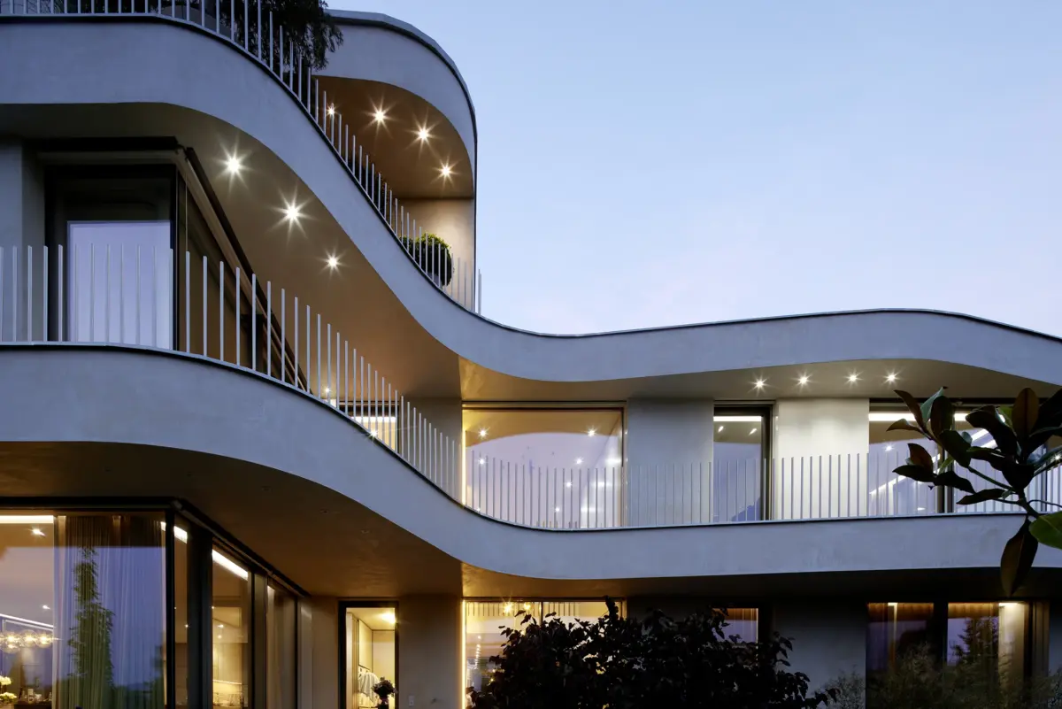 Beleuchtete geschwungene Balkone der Villa am Bodensee von Gahleitner Architekten