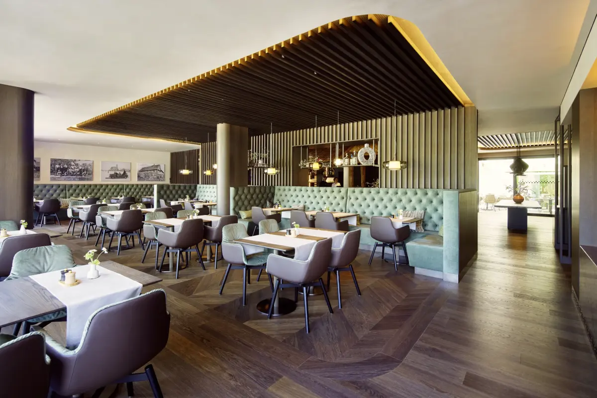 Restaurant im Hotel Gierer in Wasserburg am Bodensee mit Holzlamellendecke und grünen Samtbänken, Gahleitner Architekten, fotografiert von Architekturfotograf Roland Wimmer