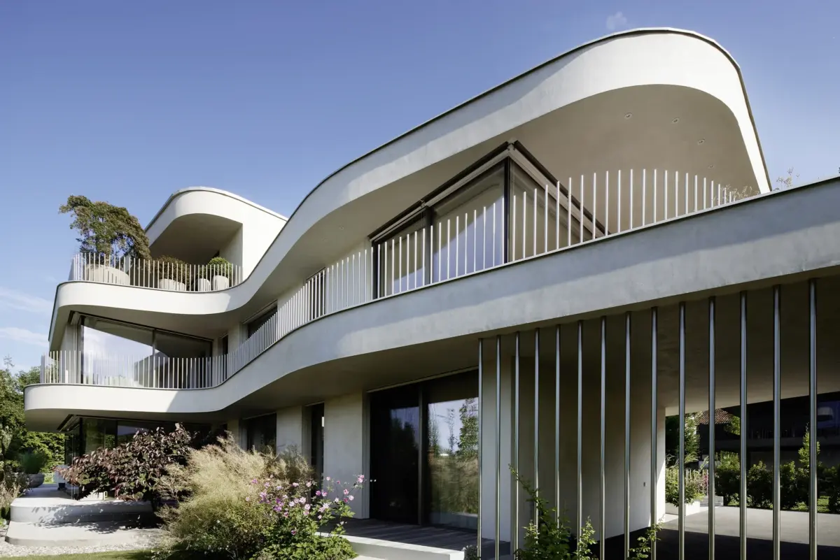 Weit auskragende, geschwungene Fassade mit Eckverglasung gegen blauen Himmel einer Villa am Bodensee bei Bregenz, Gahleitner Architekten, Architekturfotograf Roland Wimmer
