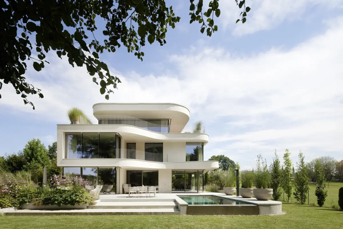 Gartenansicht mit Pool, Terrasse und geschwungener weißer Fassade einer Villa am Bodensee bei Bregenz, Gahleitner Architekten, Architekturfotograf Roland Wimmer