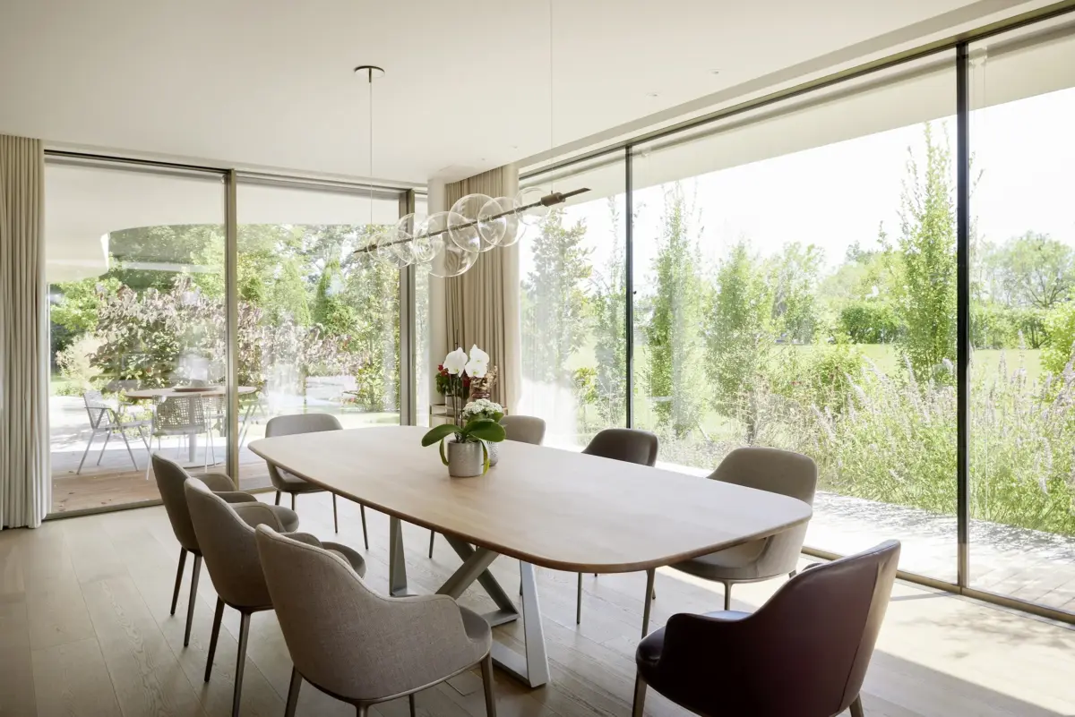 Essbereich mit Holztisch, Glasleuchte und raumhoher Verglasung zum Garten in einer Villa am Bodensee bei Bregenz, Gahleitner Architekten, Interieurfotografie Roland Wimmer