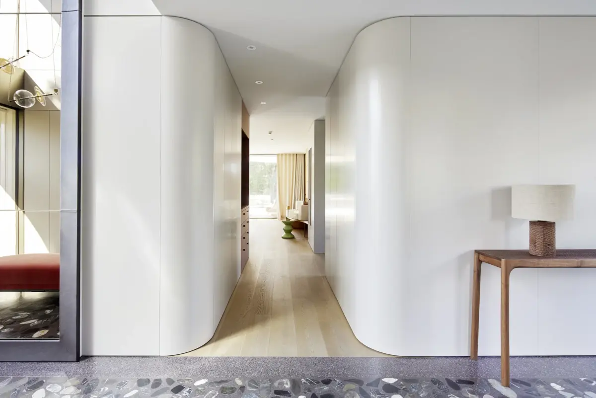 Flur zwischen weiß geschwungenen Einbauschränken mit Eichenboden und Terrazzo in einer Villa am Bodensee bei Bregenz, Gahleitner Architekten, Interieurfotografie Roland Wimmer