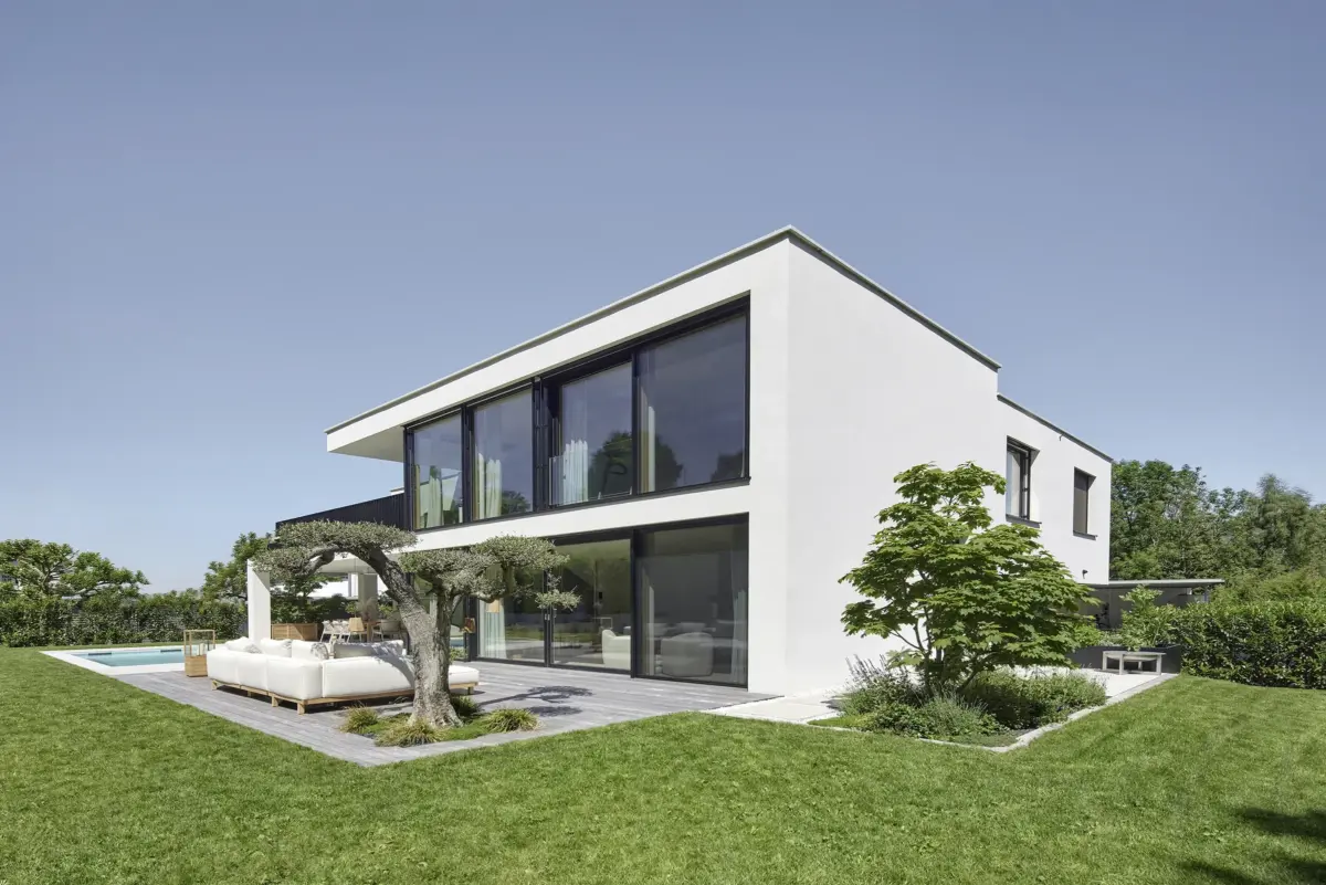 Moderne Villa in Bregenz mit großen Glasflächen, Olivenbaum und Holzterrasse, Gahleitner Architekten, fotografiert von Architekturfotograf Roland Wimmer