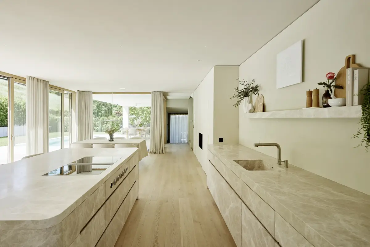 Offene Küche mit Kücheninsel aus hellem Marmor und Eichenboden in einer Villa in Bregenz, Gahleitner Architekten, Architekturfotograf Roland Wimmer