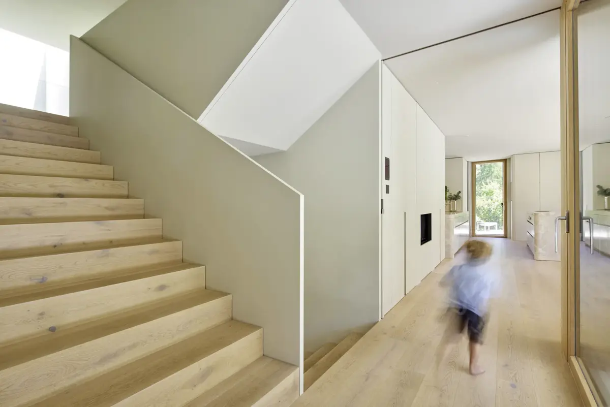 Treppe aus Eichenholz mit weißer Brüstung und Einbauschränken in einer Villa in Bregenz, Gahleitner Architekten, Architekturfotografie Roland Wimmer