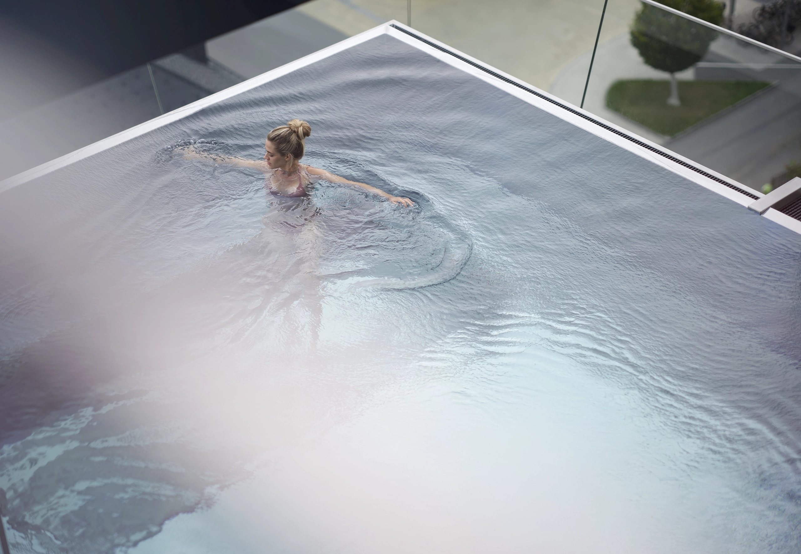 Frau schwimmt im Sky Pool des Hotels Freigold, von oben fotografiert