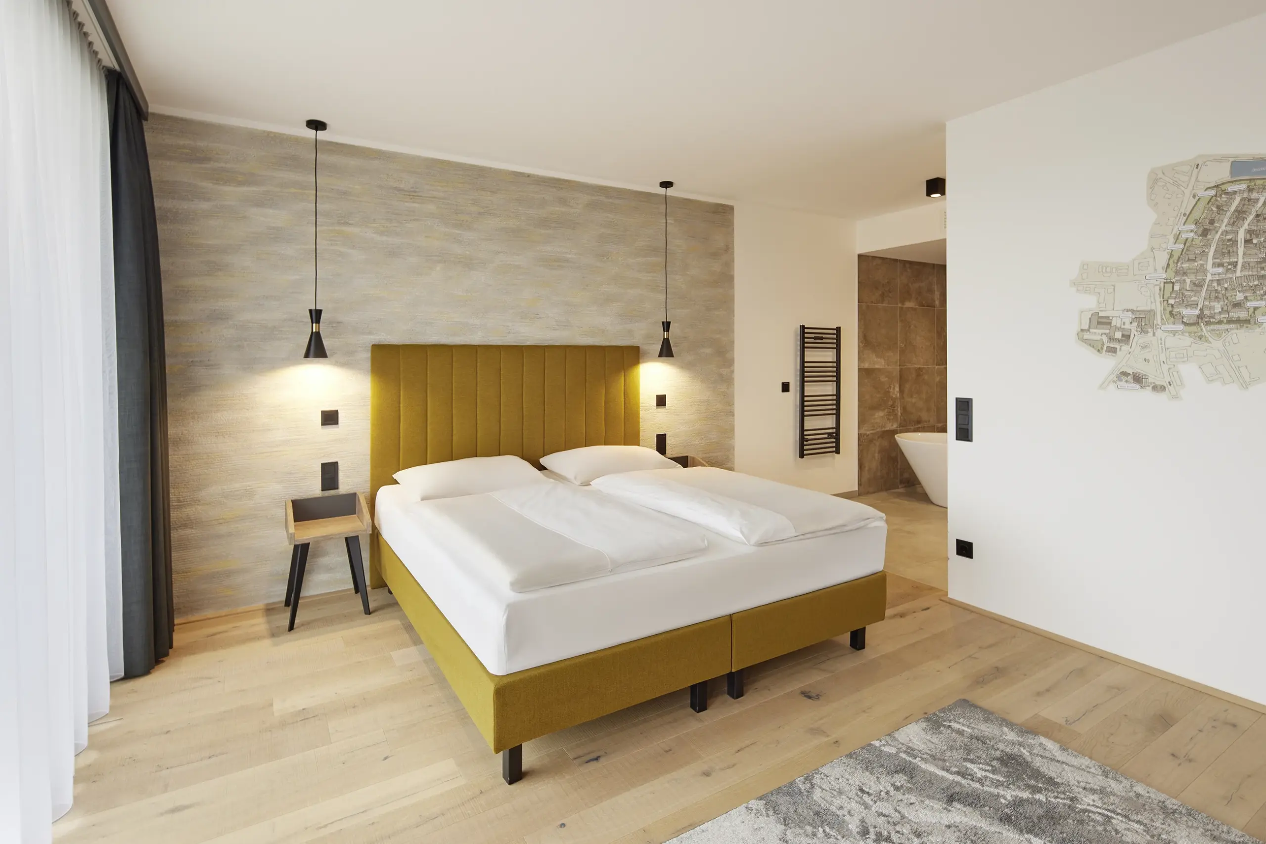 Hotelzimmer mit senfgelbem Bett und Holzboden